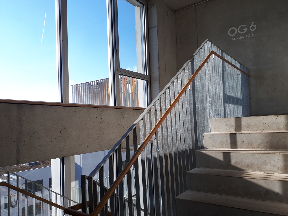Betontreppe vor großem Fenster mit Lichtspiel